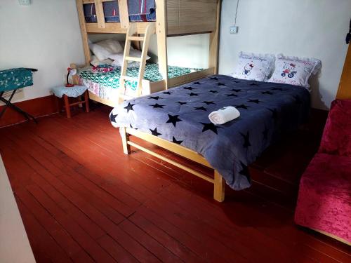 een slaapkamer met een bed en een stapelbed bij Casa de Campo-Hospedaje Munay Wasi in Tarma