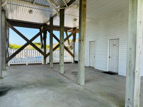 a large white building with wooden beams at Sea Biscuit in Holden Beach