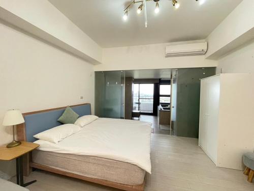 a bedroom with a large white bed and a table at Spring溫泉 in Toucheng