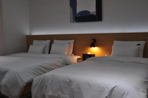 two beds sitting next to each other in a bedroom at HOUND Hotel Sangmu in Gwangju