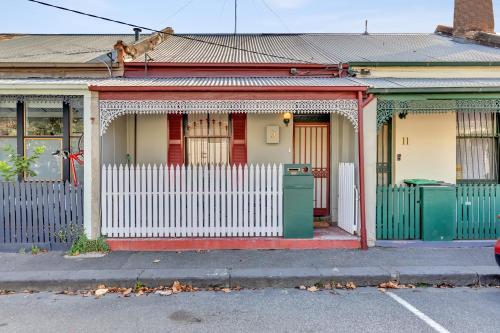 a house with a white fence in front of it at Melbourne Guest House with Parking and Courtyard in Melbourne