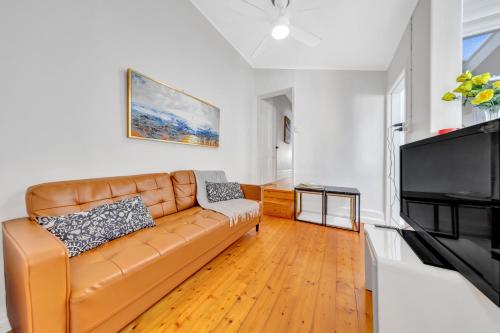 a living room with a couch and a flat screen tv at Melbourne Guest House with Parking and Courtyard in Melbourne