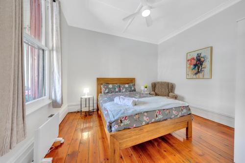 a bedroom with a bed and a chair in it at Melbourne Guest House with Parking and Courtyard in Melbourne