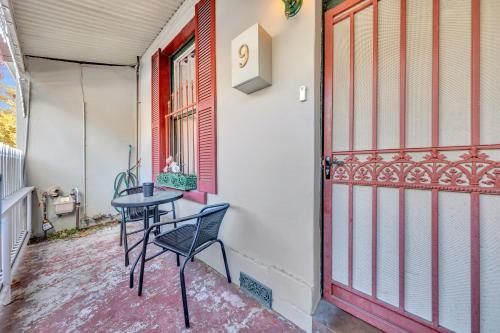 a table and a chair on a porch next to a door at Melbourne Guest House with Parking and Courtyard in Melbourne