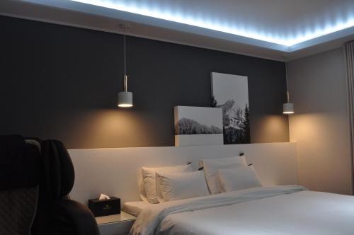 a bedroom with a bed and two pictures on the wall at HOUND Hotel Sangmu in Gwangju