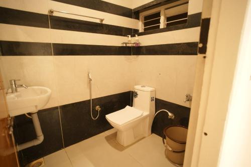 a bathroom with a toilet and a sink at Rasha residency in Kalpetta