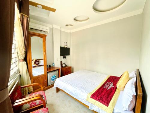 - une chambre avec un lit, une télévision et une chaise dans l'établissement Thái Thịnh Hotel, à Dong Van