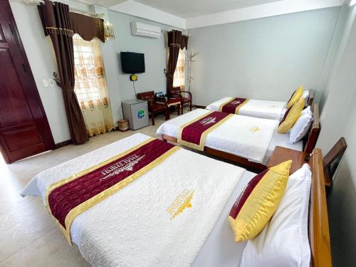 a hotel room with two beds and a television at Thái Thịnh Hotel in Dồng Văn