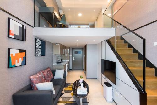 a living room with a couch and a staircase at Zun Xiang Executive Apartment - Shenzhen Futian Exhibition Center in Shenzhen