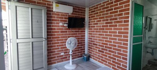 a bathroom with a brick wall and a fan at Cabaña La Gloria in San Onofre