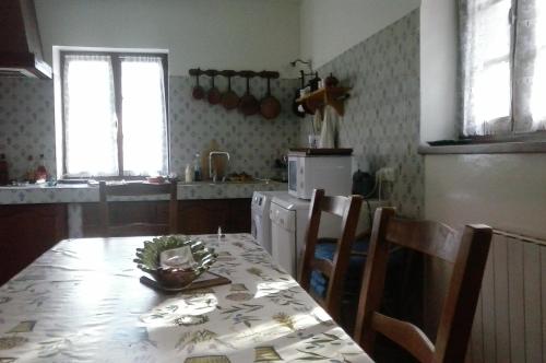 une cuisine avec une table et des chaises ainsi qu'une cuisine avec une table et une table dans l'établissement grande maison, à Cels