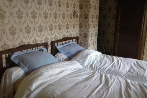 - une chambre avec 2 lits dotés de draps blancs et d'oreillers bleus dans l'établissement grande maison, à Cels