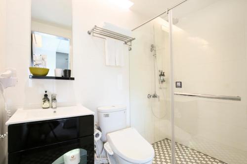 a white bathroom with a toilet and a shower at CityInn Hotel Plus - Taichung Station Branch in Taichung