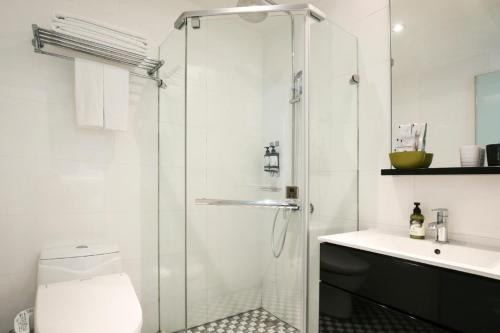 a bathroom with a shower and a toilet and a sink at CityInn Hotel Plus - Taichung Station Branch in Taichung