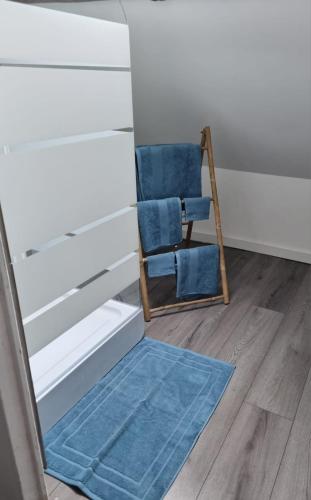 a blue chair and a mirror in a room at Chez IZZA Chambre au calme in Poulainville