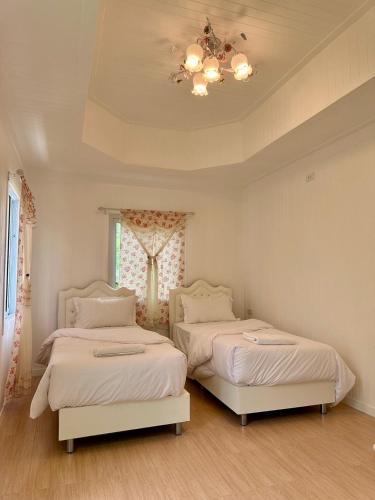 a bedroom with two beds and a chandelier at Peang Tara Cafe & Resort in Nong Khai