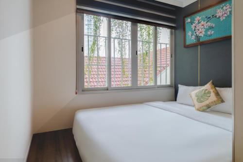 a bedroom with a white bed and a window at Aaron Boutique Hotel in Nha Trang
