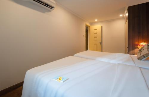 a bedroom with a white bed with a white sheets at Aaron Boutique Hotel in Nha Trang