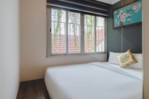 a bedroom with a white bed and a window at Aaron Boutique Hotel in Nha Trang