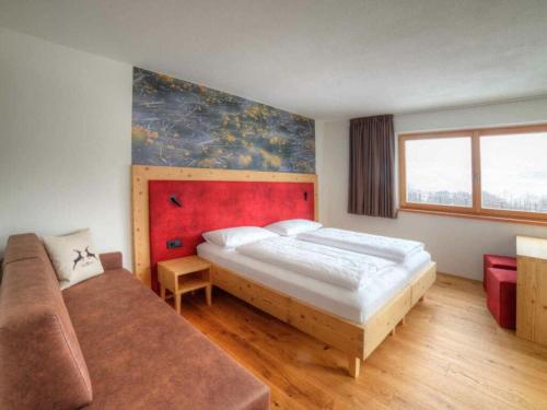 a bedroom with a large bed and a couch at Holiday apartment in St Lorenzen in Floronzo