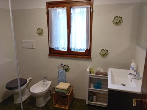 baño con lavabo y aseo y ventana en Detached house in the village Trarego with a nice view of the lake, en Trarego