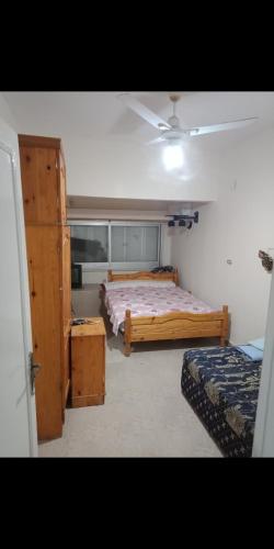 a bedroom with two beds and a window at شاليه العائلة in Qaryat Shurūq