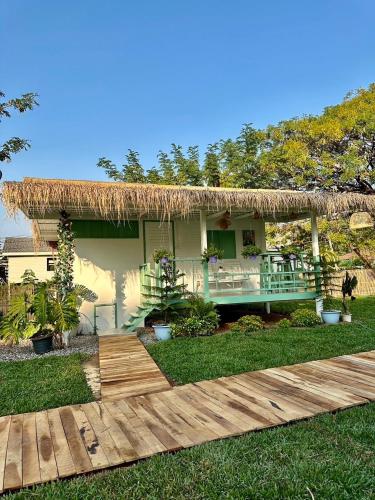 a house with a thatched roof and a wooden deck at Peang Tara Cafe & Resort in Nong Khai