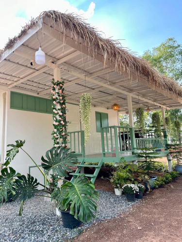 a porch with a bench under a thatched roof at Peang Tara Cafe & Resort in Nong Khai