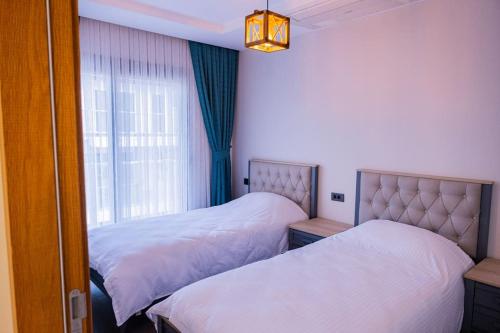 1 Schlafzimmer mit 2 Betten und einem Fenster in der Unterkunft Havuzlu lüks yeni 4 oda in Cesme