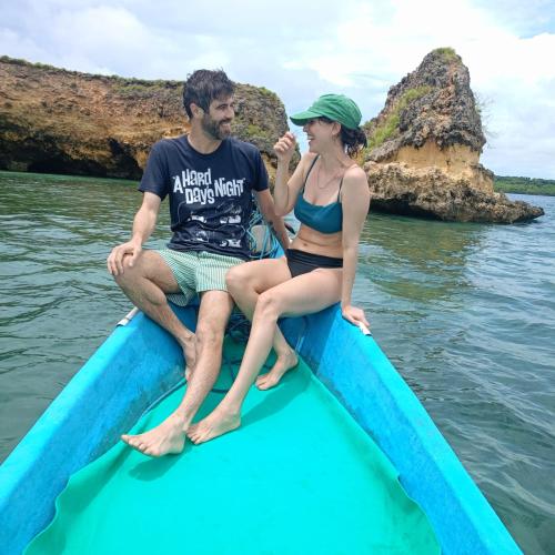 a man and a woman sitting on a blue boat in the water at Dira Bungalows in Tetebatu