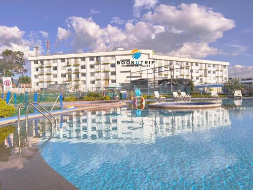un hôtel avec une piscine en face d'un bâtiment dans l'établissement Aparthotel 2km Parque del Café BOOKUTRIP, à Montenegro