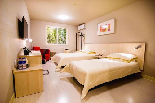 a hotel room with two beds and a television at Jinjiang Inn - Beijing Guangqumen in Beijing
