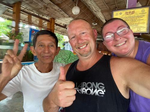 three men giving the thumbs up sign in a store at Ba Hung homestay in Ấp Hòa Phú (2)
