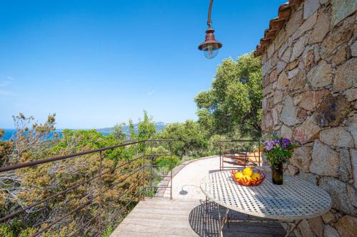 une table avec un bol de fruits sur un balcon dans l'établissement Maisonnette en plein maquis vue splendide à 5 min du centre et de la plage, à Calvi