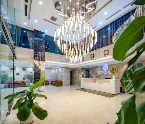 a lobby with chandeliers and plants at Gibson Hotel Nha Trang in Nha Trang