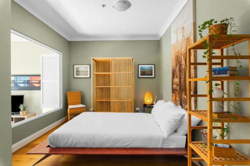 'Laube 105' Modern Inner-city Sanctuary with Balcony في سيدني: غرفة نوم مع سرير ورف كتاب