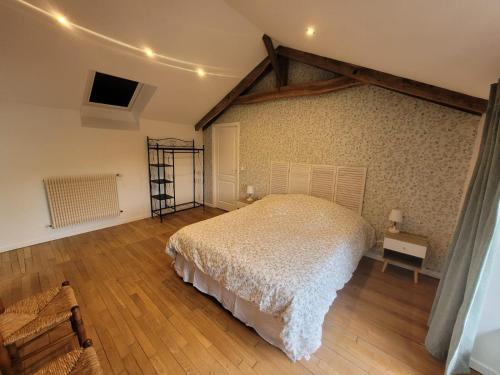 una camera con letto bianco e pavimento in legno di LE RELAIS VAUBAN 