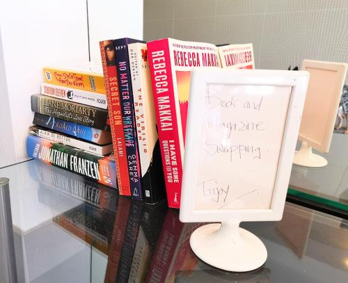 a stack of books on a table with a sign at King on Sturt in Adelaide