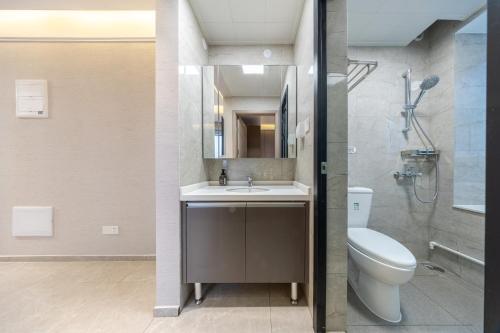 een badkamer met een wastafel, een toilet en een douche bij Gangxia International Hotel-深圳福田会展中心岗厦地铁站店 in Shenzhen