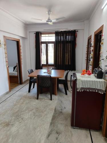 sala de estar con mesa de madera y sillas en RK homestay, en Udaipur