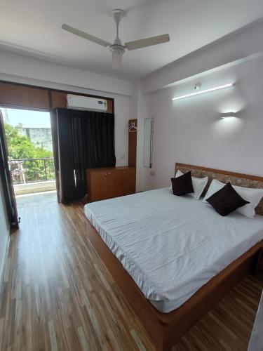 sypialnia z łóżkiem z białą pościelą i oknem w obiekcie RK homestay w mieście Udaipur