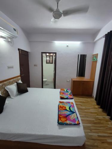 una camera da letto con un letto bianco e un cuscino sopra di RK homestay a Udaipur