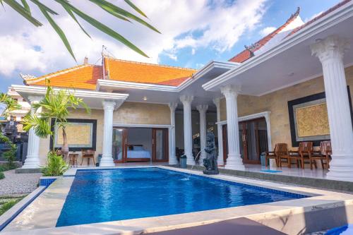 a villa with a swimming pool in front of a house at Abian nyuh lovina in Lovina