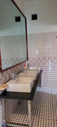 un bagno con tre lavandini e un grande specchio di Thap Tam Royal Hotel a Ninh Binh