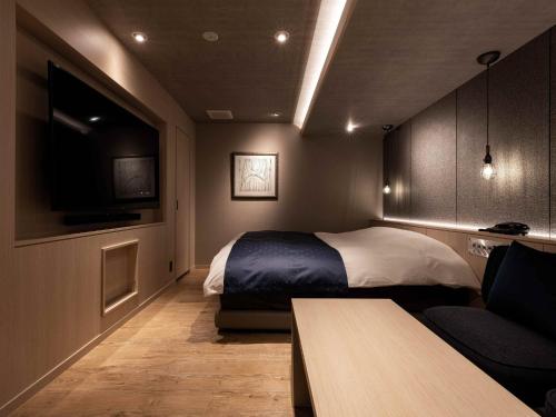 a bedroom with a bed and a tv and a couch at Y-HOTEL - Vacation STAY 22330v in Hiroshima