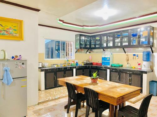 Santa Monica的住宿－Masayay Homestay With Starlink Wifi，厨房配有木桌和冰箱。
