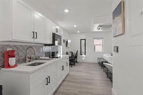 a kitchen with white cabinets and a living room at New Season Royals, Airport West in Chester