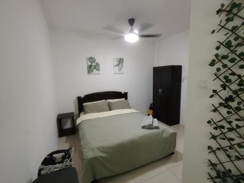 um quarto com uma cama e uma ventoinha de tecto em JNJ Miri Homestay - Miri Serene Shangrila, Luak with 4-bedroom em Miri