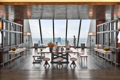 a dining room with a table and some windows at Rosewood Phnom Penh in Phnom Penh