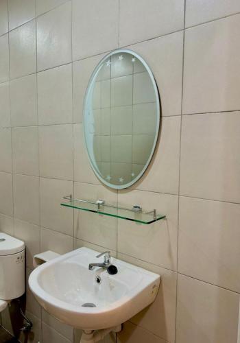 uma casa de banho com um lavatório e um espelho na parede em 3N Homestay Putrajaya em Putrajaya